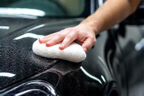 Technician carefully washing a car exterior